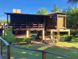 una casa de madera con una valla delante en Rio Manso Tigre en Tigre