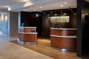 a lobby with a reception desk and a television at Sonesta Select Boston Milford in Milford