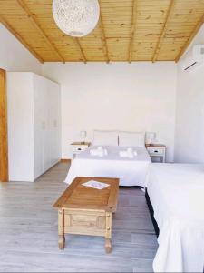 1 dormitorio con 2 camas y techo de madera en Los Bungalows, en José Ignacio