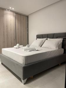 een slaapkamer met een groot bed met witte lakens bij Saranda Lux Apartments in Sarandë