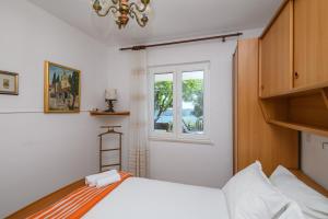 オラサックにあるApartment MARIO - veliki stan za odmor - terasa- vrt - bazen - pogled more, izoliranのベッドと窓のある寝室 +35枚の写真