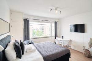 1 dormitorio con cama, mesa y ventana en Norden Homes Turku 2-Bedroom Nordic Apartment, en Turku