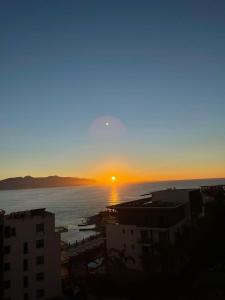 een zonsondergang boven de oceaan in een stad bij Saranda Lux Apartments in Sarandë