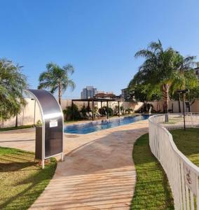 a swimming pool in a park with a fence at Loft encantador e refinado in Ribeirão Preto