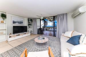 a living room with a couch and a tv at Marcoola Beach Resort in Marcoola