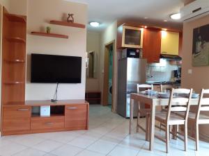 un soggiorno con TV e tavolo con sedie di Apartment EVA a Vodnjan (Dignano)