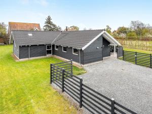 una casa negra con una valla delante en 14 person holiday home in Sydals, en Høruphav