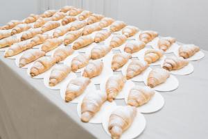 um monte de croissants em pratos numa mesa em Hotel Elefantino Grey - Inclusi Colazione & Brunch fino alle 13-00 - Vicinissimi a Mirabilandia em Milano Marittima