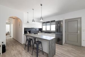 una cocina blanca con una gran isla con taburetes en White Pearl Villa Naxos with Private Swimming Pool, en Naxos Chora 47 fotos más