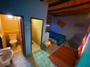 een badkamer met een wastafel, een toilet en een spiegel bij Auberge Kasbah Des Dunes in Merzouga