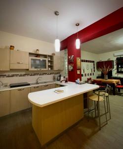 a kitchen with a white counter and a red wall at A CASA DI BOB in Matera