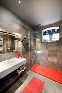 bagno con lavandino e doccia con tappeto rosso di Charming House Iqs a Venezia