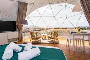 Habitación con una gran cúpula de cristal con mesa y sillas. en Eslanzarote Eco Dome Experience en Teguise