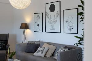 a living room with a gray couch and pictures on the wall at White Pearl Villa Naxos with Private Swimming Pool in Naxos Chora