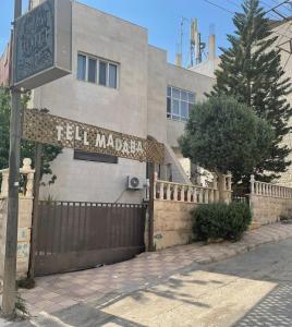 a building with a sign that reads tell manemen at Tell Madaba Hotel in Madaba