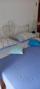 a bed with blue sheets and pillows on it at Apartmani Kunjasic in Trstenik