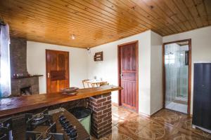 a kitchen with a stove and a wooden ceiling at Chalés Cerejeira in Visconde De Maua