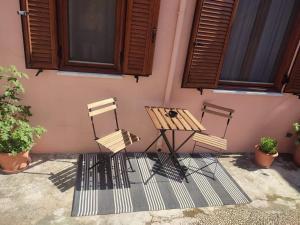 a picnic table and two chairs in front of a house at Old Town Maisonette in Rhodes Town