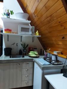 a kitchen with a sink and a microwave on a counter at Cabanas Bouganville in Monte das Gameleiras