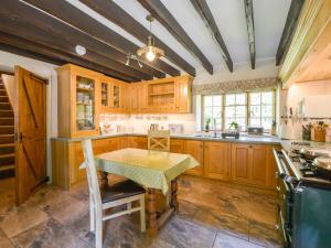 a kitchen with wooden cabinets and a table at Bagtor Mill in Newton Abbot