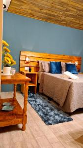 1 Schlafzimmer mit 2 Betten mit blauen Kissen und einem Tisch in der Unterkunft Pousada Recanto dos Canyons in Praia Grande