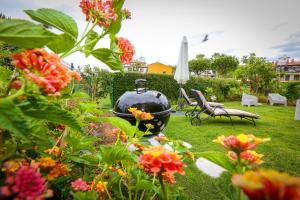 ein großer Grill in einem Garten mit Blumen im Hof in der Unterkunft Pura Villa- Buganvillas Ayamonte in Ayamonte + 67 Fotos