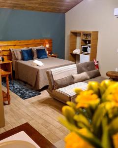 uma sala de estar com uma cama e um sofá em Pousada Recanto dos Canyons em Praia Grande