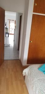 a bedroom with a bed and a wooden door at Exelente Departamento in La Plata +6 photos