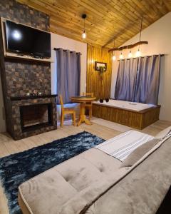 uma sala de estar com uma cama grande e uma lareira em Pousada Recanto dos Canyons em Praia Grande