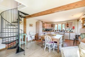 a kitchen and dining room with a table and a staircase at The Cart Lodge in Halesworth