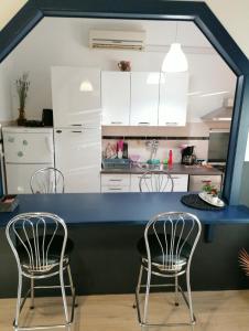a kitchen with a blue counter and chairs at Apartment Nicol in Pula