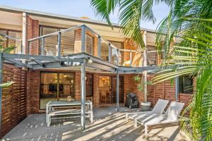 a patio of a house with a wooden deck at Calinda Sol 11 in Byron Bay