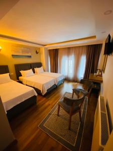 una habitación de hotel con 2 camas y una silla en PALMERA OLD CITY en Estambul