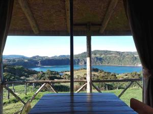 a view of a lake from the inside of a cabin at Cabaña pumillahue rural in Ancud