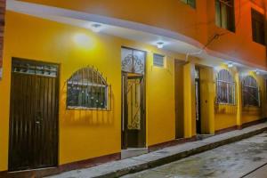 a yellow building with doors and windows on it at Residencial el Valle in Huaraz