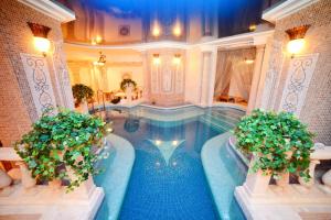 a swimming pool in a house with two plants at Visak Hotel in Kyiv