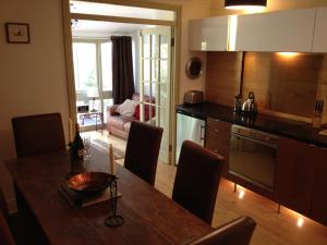 a kitchen with a wooden table and a dining room at Belvedere Villas in Bath