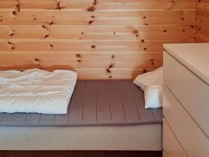 een kamer met een bed en een houten muur bij Apartment Sjernarøy in Sjernarøy