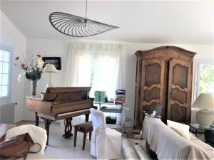 Una sala de estar con un piano y un sofá. en Attractive Holiday Home in C reste with Pool, en Céreste