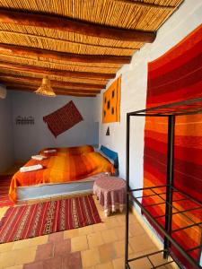 a bedroom with two twin beds and a staircase at Auberge Kasbah Des Dunes in Merzouga
