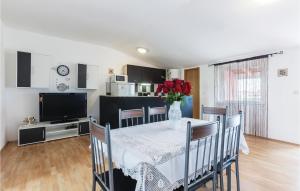 a dining room with a table with a vase of flowers on it at Nice Apartment In Vodnjan With 2 Bedrooms And Wifi in Vodnjan