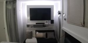 a white room with a television and a bed at apartment villas de loiza in Canovanas