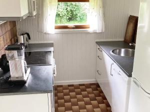 a small kitchen with a sink and a stove at 6 person holiday home in Idestrup in Marielyst