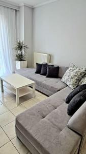 a living room with a couch and a coffee table at Ivanna apartment in Nea Moudania