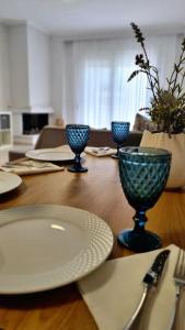 - une table en bois avec des assiettes et des verres à vin dans l'établissement Ivanna apartment, à Nea Moudania