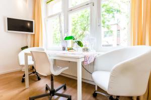 Zimmer mit einem Schreibtisch, 2 Stühlen und einem Fenster in der Unterkunft Altstadt - CGN Apartments in Köln