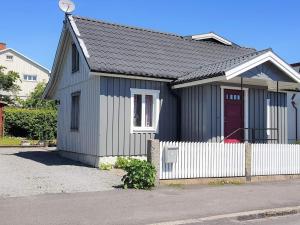 una pequeña casa con una cerca blanca delante de ella en Holiday home SÖLVESBORG XVI, en Sölvesborg