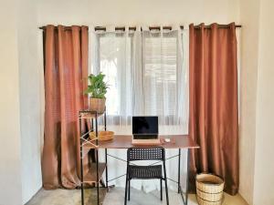 a desk with a laptop on it in front of a window at Yas villas homestay in General Luna