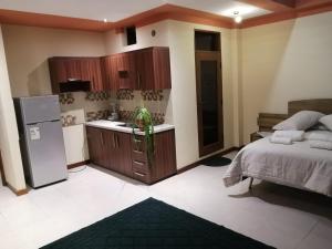 a kitchen with a bed and a refrigerator in a room at Belle Ville in Sucre