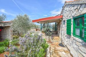 a stone house with green windows and a garden at House Murtelica in Tkon +20 photos